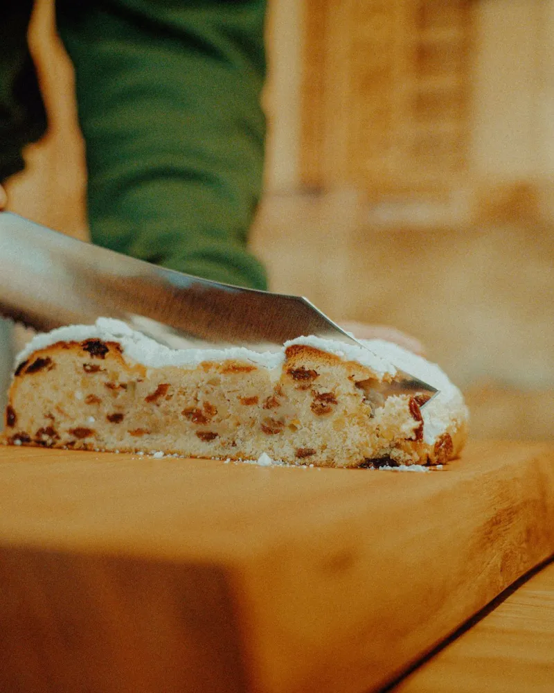 Stollen wird auf dem Holzbrett angeschnitten